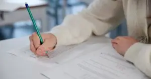 Free Articles 2 education exam and hands at desk with test paper 2026 03 25 03 54 15 utc